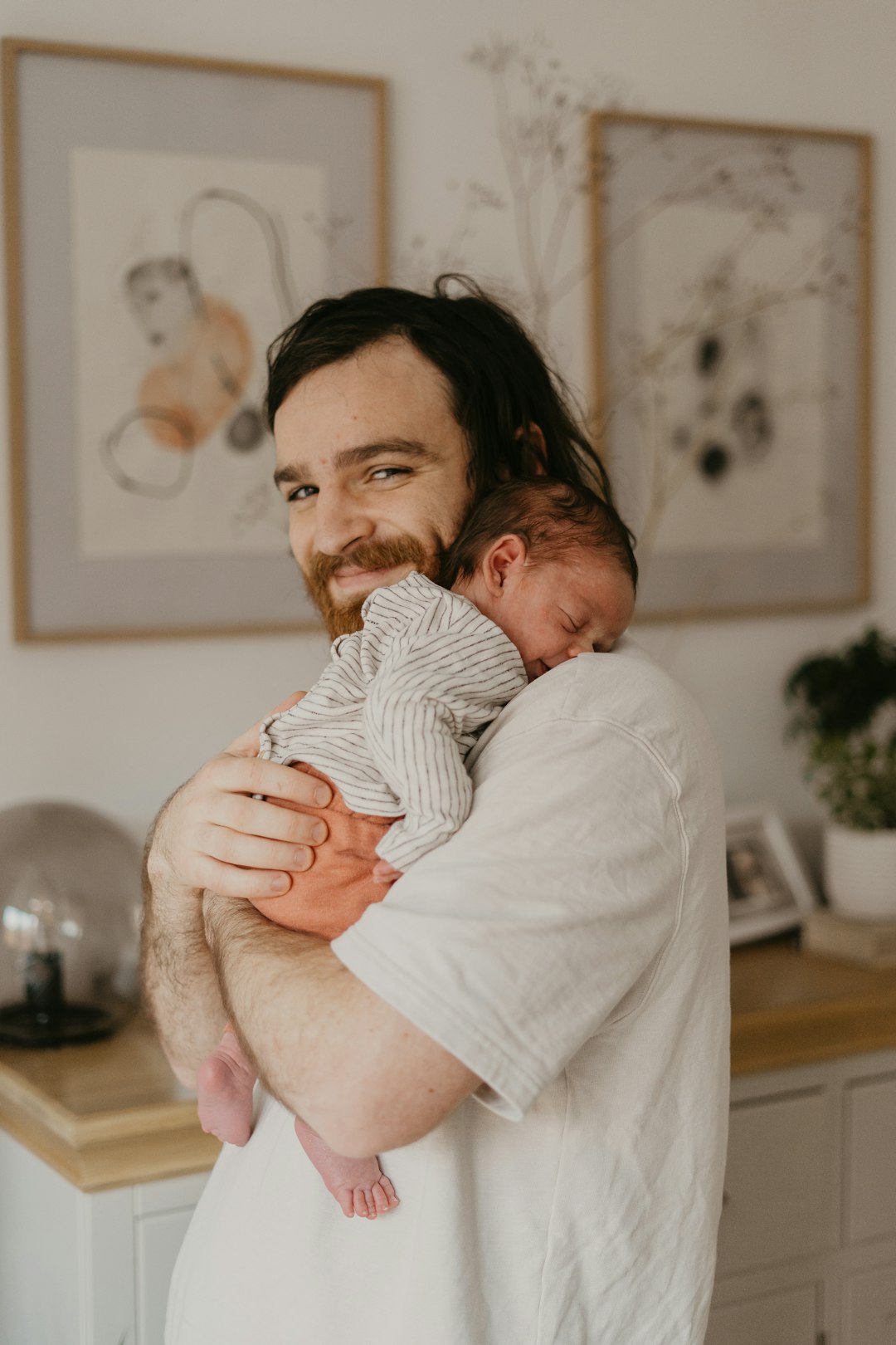 A father holding his baby at home